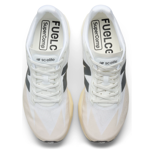 Et par New Balance Fuelcell Supercomp Elite V5 Dame linen løbesko set ovenfra, i hvid med sorte og beige detaljer, overdel i mesh og fed "FuelCell SuperComp Elite V5"-branding på indersålen og tungen.