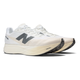 Et par New Balance Fuelcell Supercomp Elite V5 løbesko, Herre, Linen, med sorte såler og grå N-logoer på siderne vises i en lille vinkel på en almindelig hvid baggrund - ideel til konkurrence.