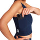 En person iført en mørkeblå W Combat Rib Crop Top, der lægger en smartphone i sidelommen.