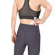 En person, der har en sort sports-BH og et par grå Saysky W Combat+ Rib Long Tights til kvinder på, lægger en pude i lommen i linningen bag på leggingsene.