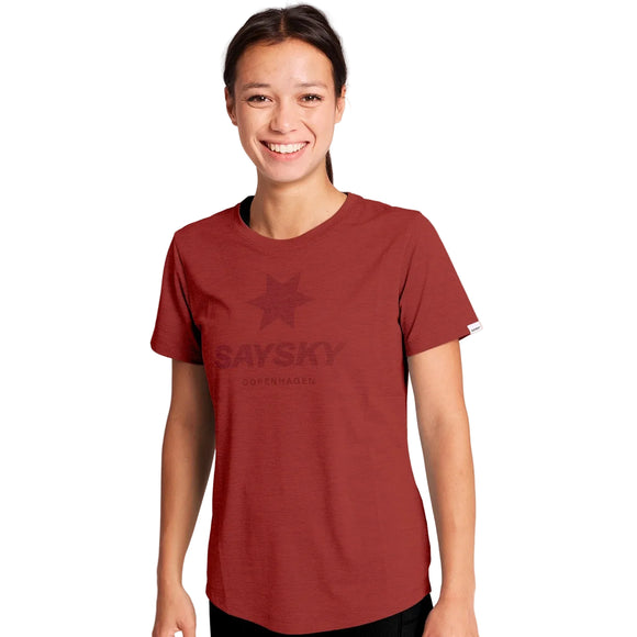 En smilende kvinde iført en rød W Logo Combat Pro-T-shirt med et Dame-logo og tekst trykt på brystet.