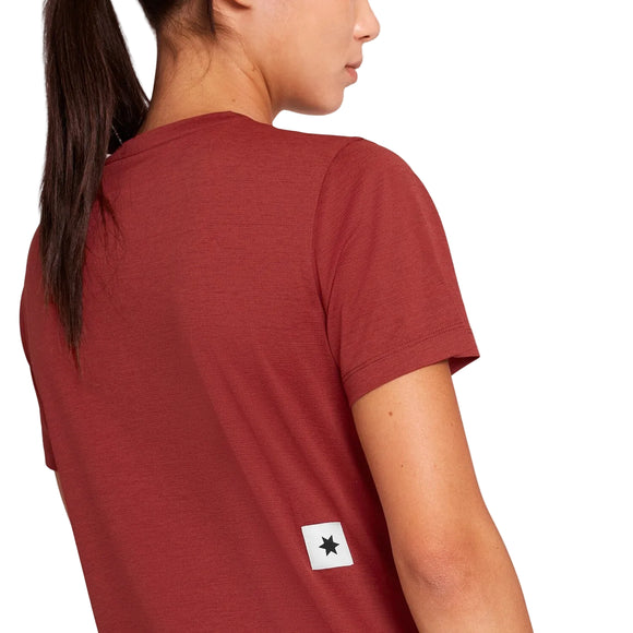 En person iført en rød W Logo Combat Pro-T-shirt fra Dame med et lille firkantet hvidt logo med en sort stjerne nederst på ryggen.