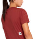 En person iført en rød W Logo Combat Pro-T-shirt fra Dame med et lille firkantet hvidt logo med en sort stjerne nederst på ryggen.