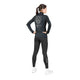 En person står med ryggen til og har en sort Saysky W Tiger Pace Half Zip Long Sleeve på med et tigermotiv på ryggen samt matchende sorte leggings.