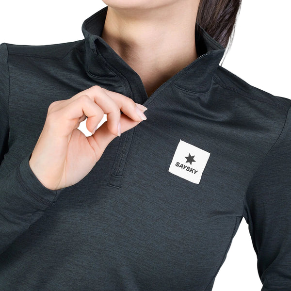 En person iført en sort Saysky W Tiger Pace Half Zip Long Sleeve, en langærmet sportsbluse med halv lynlås og et logo-mærke på brystet.