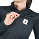En person iført en sort Saysky W Tiger Pace Half Zip Long Sleeve, en langærmet sportsbluse med halv lynlås og et logo-mærke på brystet.