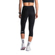 En person står med ryggen til kameraet iført Fusion 3/4 Training Tights, Dame, SuperBlack, hvide sokker med VISION FUSION-tekst, hvide sportssko og en sort crop top.