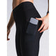 En kvinde placerer en smartphone i sidelommen på Fusion Hot X-Long Tights, Dame, Black. Kun hendes underkrop og overben er synlige mod en neutral baggrund.