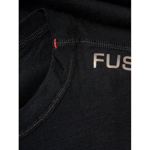 Nærbillede af halsudskæringen på Fusion Merino 150 LS til kvinder i sort, der fremhæver detaljerede syninger, en lille rød søm og et delvist gråt "FUS"-branding på stoffet.