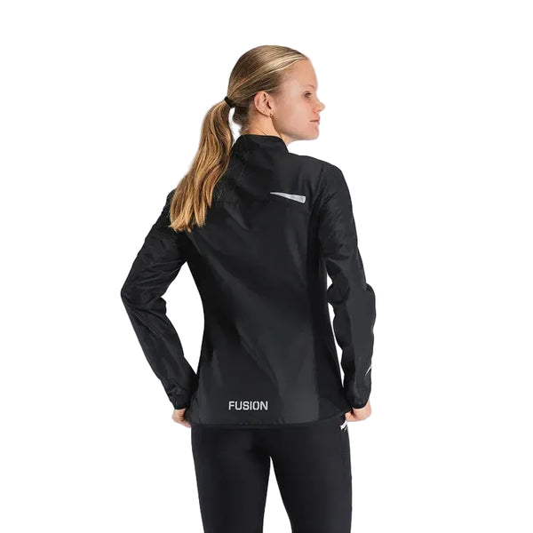 En kvinde med blondt hår i hestehale står med ryggen til kameraet iført den sorte Fusion S1 Run Jacket til kvinder på en almindelig lysegrå baggrund.