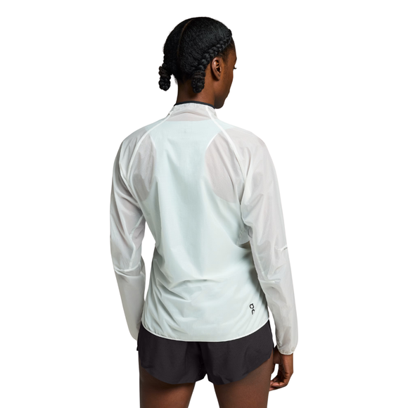 En person med flettet hår ses bagfra iført On Zero Jacket, Dame, White og sorte shorts på en almindelig hvid baggrund.