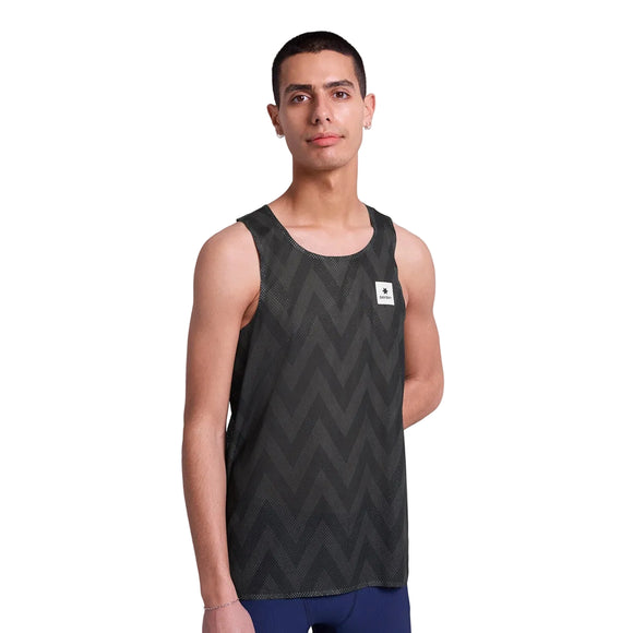En person er iført en sort Saysky Zig Zag Flow Air Singlet, Herre, med et diskret zigzagmønster og et lille hvidt rektangulært logo på brystet, og står foran en almindelig hvid baggrund.