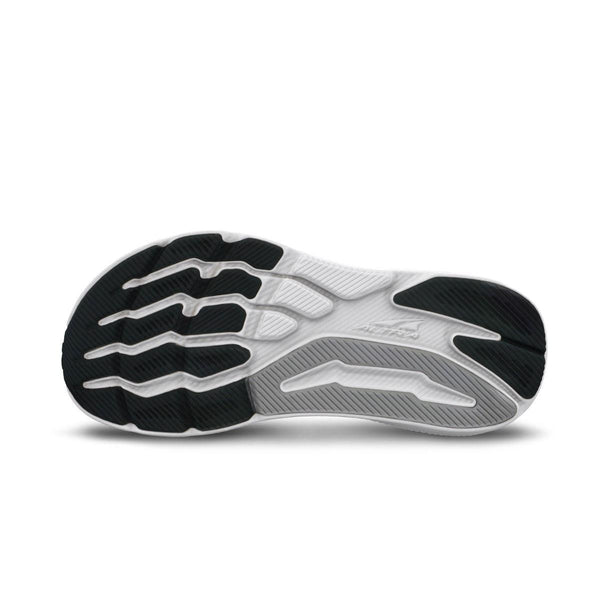 Billedet viser sålen på Altra's Experience Form, Dame, Black sneaker med sorte og hvide farver. Strukturerede greb, riller og bølgemønstre giver greb og fleksibilitet, mens Altras logo og FootShape-pasform vises i midten.