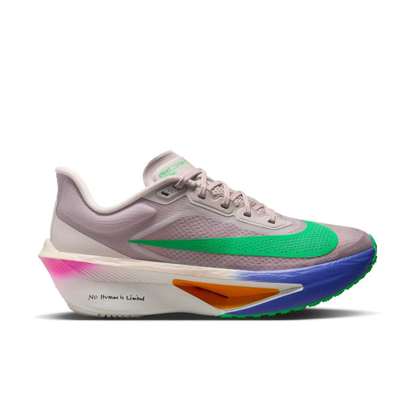 En lysegrå løbesko med grønne og blå detaljer, en stor grøn swoosh, en tyk mellemsål med pink og orange gradueringer og teksten NO HUMAN IS LIMITED trykt på siden af sålen.