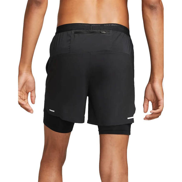En person ses bagfra iført Nike Stride 5" 2in1 Shorts til mænd i sort, der viser pasformen, Dri-FIT-teknologien, det indre kompressionslag og de slanke designdetaljer med fokus på underkroppen og benene.