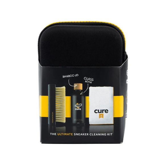Et elegant sort Crep Protect Cure Shoe Cleaning Kit, Unisex fra Crep Protect, med en børste, en flaske med bambuslåg og en hvid klud - alt sammen delvist synligt i æsken med tydelige produktdetaljer.