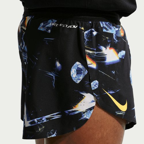 Nærbillede fra siden af en person iført Nike Dri-FIT ADV 2" Brief-Lined Running Shorts til mænd i Black/Laser Orange med et abstrakt blåt og orange diamantmønster, et gult Nike-logo og "DRI-FIT ADV" nær linningen.