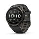 Et Garmin fenix 9 Pro InReach 43 mm AMOLED-multisport-smartur i Carbon Grey DLC-titanium med et sort armbånd med stenmønster vises på en hvid baggrund, let vinklet mod højre. Den runde digitale skærm viser klokkeslættet (10:10), skridttælleren, puls og batteriniveau.