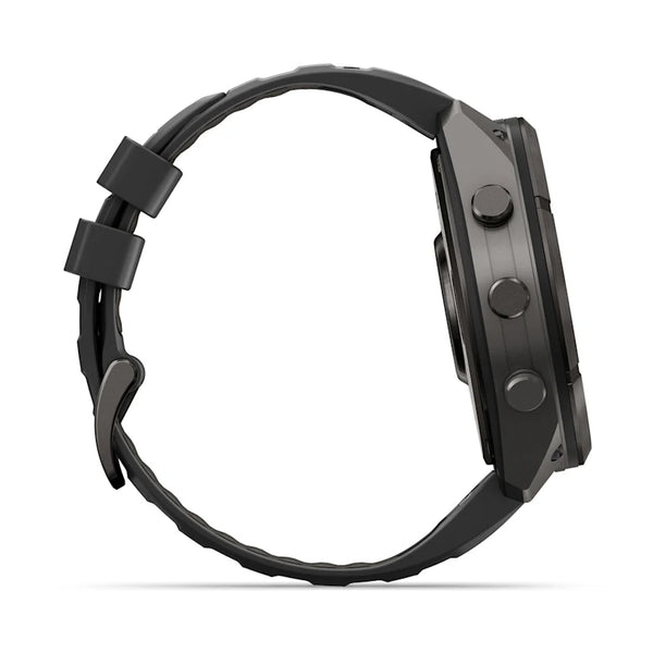 Set fra siden: et sort Garmin fenix 9 Pro InReach 51 mm multisport-smartur med et kulgråt DLC-titaniumhus, en småstensgrå silikonerem med strukturerede detaljer og tre runde knapper på højre side. Det robuste, kantede design træder tydeligt frem på dette billede, selvom urskiven ikke er synlig.