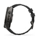Set fra siden: Et Garmin fenix 9 Pro InReach 51 mm smartwatch i Carbon Grey DLC-titanium med et sort og småstensgråt silikonerem med en struktureret, mat overflade og en rektangulær lås. Der ses to knapper på venstre side, mens urskiven er skjult for at fremhæve den robuste konstruktion, der er ideel til inReach-kompatibilitet.