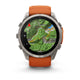 Garmin fenix 9 Pro InReach 51 mm multisport-smarturet, der har et titaniumhus og et silikonerem i farverne Autumn Orange og Spark Orange, ses her set forfra på en hvid baggrund. Den runde skærm viser et topografisk kort med grønt terræn, vandarealer og rutelinjer.