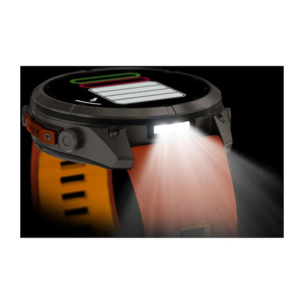 Et Garmin fenix 9 Pro InReach 51 mm-smartur med titaniumhus og et silikonearmbånd i farverne Autumn Orange og Spark Orange viser træningsdata på skærmen, mens den kraftige LED-lommelygte på siden er tændt og oplyser området foran og under uret.