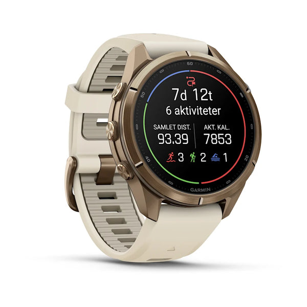 Garmins fenix 9 Pro inReach AMOLED 43 mm, som her ses i farven Autumn Gold Titanium med en silikonestrop i farverne Cream og French Grey, er et multisport-smartur med en rund skærm, der på elegant vis viser statistikker som samlet distance, forbrændte kalorier og antal aktiviteter. Tre robuste sideknapper på metalhuset understreger urets avancerede funktionalitet og holdbare design.