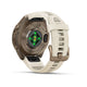 Et nærbillede af bagsiden af et Garmin fenix 9 Pro inReach AMOLED 43 mm multisport-smartur med et urhus i farven Autumn Gold Titanium og en silikonereim i farverne Cream og French Grey. Grønne sensorlamper lyser på undersiden af uret, hvor der er indgraveret tekst langs kanterne.