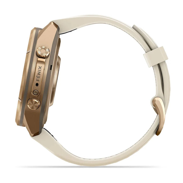 Her ses et billede af Garmin fenix 9 Pro inReach AMOLED 43 mm-smarturet set fra siden. Uret har et hus i farven Autumn Gold Titanium med indgraveringen »FENIX« og er udstyret med et cremefarvet silikonerem i farven French Grey med spænde. To runde knapper ses på huset mod en hvid baggrund.