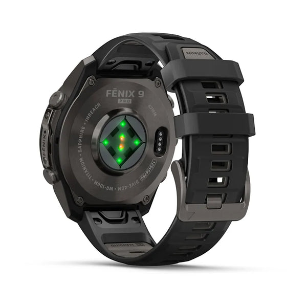 Her ses en Garmin fenix 9 Pro inReach 47 mm i Carbon Grey DLC-titanium med en sort/pebblegrå silikonerem set bagfra, hvor den optiske pulssensor, der udsender grønt lys, og metalspænden fremhæves.