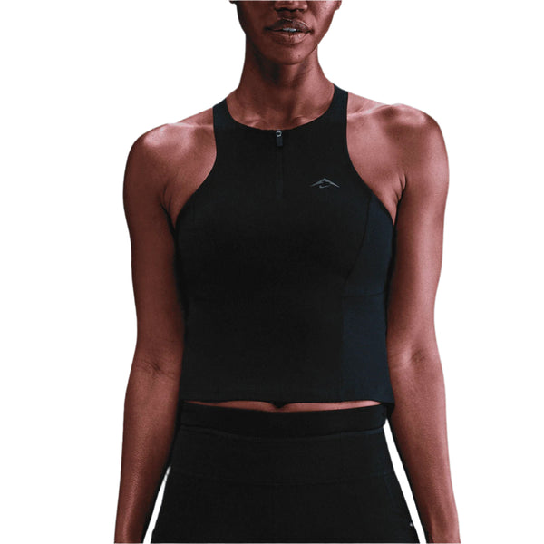 En person iført en ærmeløs Nike Outdoor Bra Tank i Black/Summit White, fotograferet fra skuldre til hofter mod en hvid baggrund.