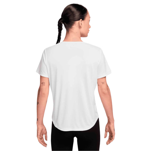 En person med en flettet frisure ses bagfra iført en Nike Dri-FIT kortærmet løbetop til kvinder i hvid/reflekterende sølv og sorte bukser på en hvid baggrund.