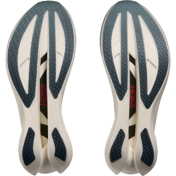 Et par Hoka Cielo X1 3.0 unisex-såler set nedefra, der viser en hvid base med mørkegråt gummigreb og et rødt logo midt på foden - designet til maratonpræstation i Alabaster/Yellow Gold-farve.