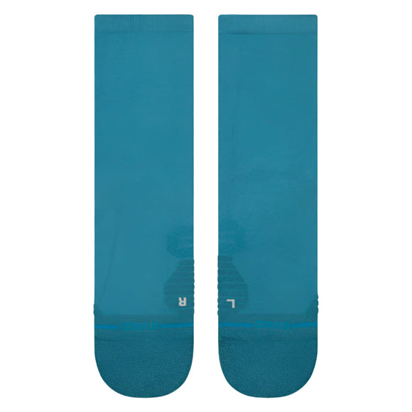 Et par Stance Teal Light Crew unisex strømper i blågrøn er lagt fladt med L- og R-tåmarkeringer, der viser venstre og højre. Disse åndbare sportssokker har en ribbet sektion ved tæerne for ekstra komfort.