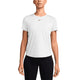 En kvinde står med front mod en hvid baggrund, klædt i sorte bukser og en Nike Dri-Fit Short-Sleeve Top (Dame) i hvid/sort, fremstillet af genanvendt polyester med et lille sort Nike-logo på brystet.