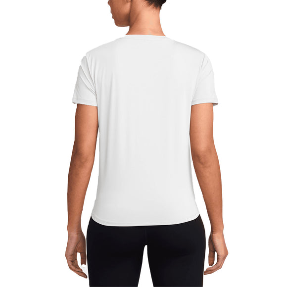 En kvinde kigger væk fra kameraet i en Nike Dri-Fit Short-Sleeve Top, Dame, White/Black, sammen med sorte bukser. Baggrunden er helt hvid.