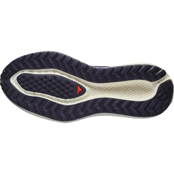 Nærbillede af Salomon Aero Glide 3 GRVL løbesko til grus (Dame, Astral Aura/Vanilla Ice/Haute Red), der viser en struktureret slidbane i mørk lilla og off-white med en rød trekant for greb og komfort, forstærket af Energy Foam EVO-dæmpning.