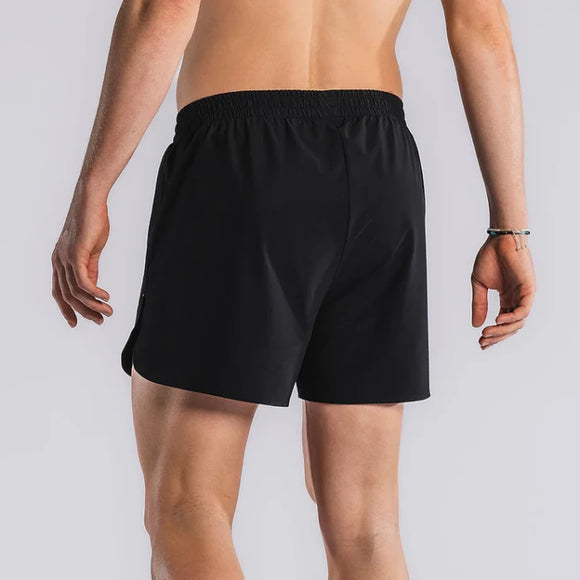 En person vender ansigtet væk fra kameraet iført Fusion Run Shorts, Herre, Black. Armene er afslappede langs siden mod en almindelig, lys baggrund.