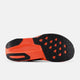 Billedet viser sålen på New Balance FuelCell Rebel V5 Dame i Urgent Red/Black/Silver Metallic, der har et struktureret mønster med trekantede former og zigzag-riller for bedre greb.