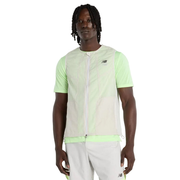 En mand står og kigger fremad iført en grå New Balance RC Vest til mænd og lyse sportsshorts med New Balance-logoer, alt sammen på en almindelig hvid baggrund.