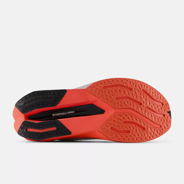 Billedet viser den lysende orange og sorte sål på New Balance Fuelcell Supercomp Trainer V3, Herre, Urgent Red set nedefra, med struktureret slidbanemønster og ENERGY ARC-tekst på midtfoden.