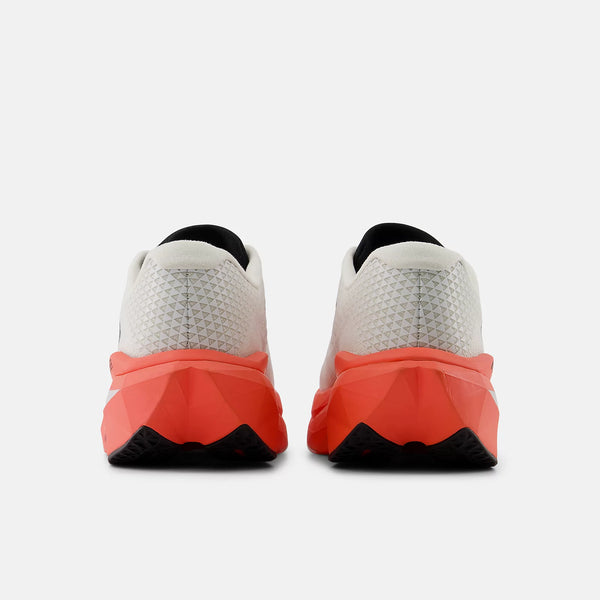 Et par New Balance Fuelcell Supercomp Trainer V3, Herre, Urgent Red vises bagfra med hvid struktureret overdel og en lysende orangerød FuelCell-mellemsål på en almindelig hvid baggrund.