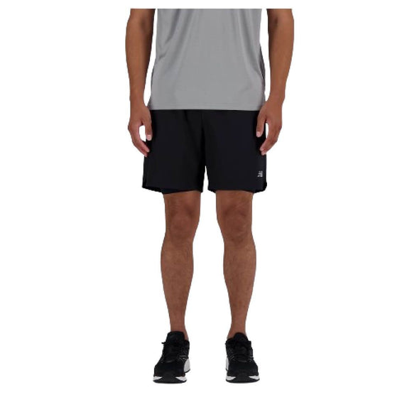 Kun den nederste halvdel af en person er synlig, når vedkommende står på en hvid baggrund iført New Balance AC Lined Shorts 7" til mænd i sort.