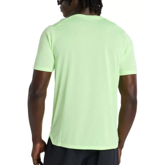 En person med mørk hud og skulderlangt hår ses bagfra iført en New Balance Athletics T-Shirt, Herre, Afterglow Heather, i lysegrøn og sorte shorts. T-shirten har ingen synlige logoer og er lavet af svedtransporterende materiale.