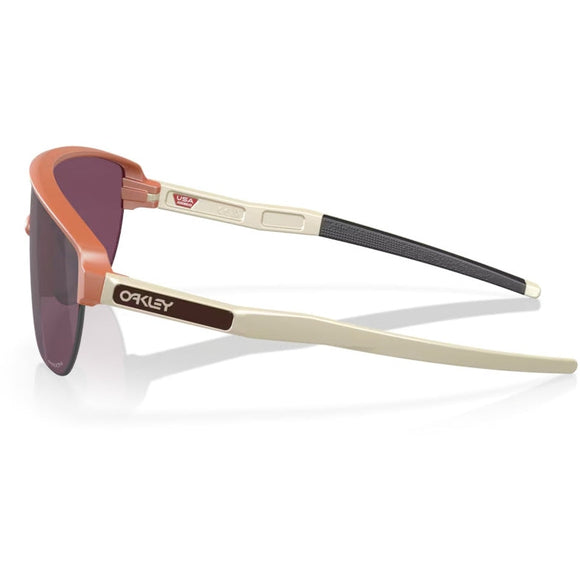 Oakley Corridor unisex-solbriller med Prizm Black-glas, et mat ingefærfarvet stel uden kanter, offwhite-arme og Oakley-logo på siden.