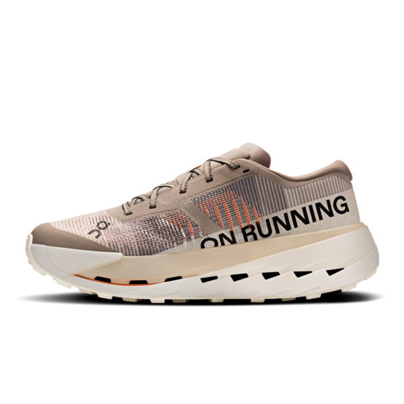 On Cloudultra Pro Herre i Cinder/Pearl har en beige og lysebrun overdel, sorte snørebånd, en tyk råhvid sål og et fedt ON RUNNING-branding. Denne moderne trailløbesko har et struktureret design, der er ideelt til eventyrlige løbeture udendørs.