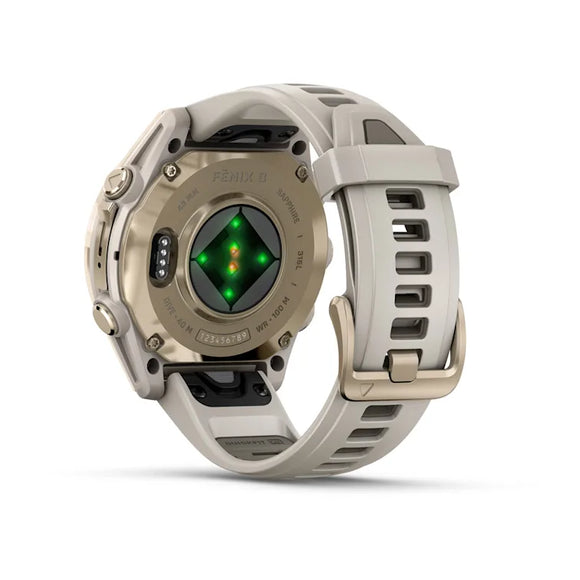 Et Garmin Fenix 8 Amoled Sapphire Titanium 43 mm i Soft Gold/Dark Sandstone vises fra bagsiden med sensorer med grønt og gult lys og en silikonerem med metalspænde. "Fenix 8" er synlig på bagsiden.