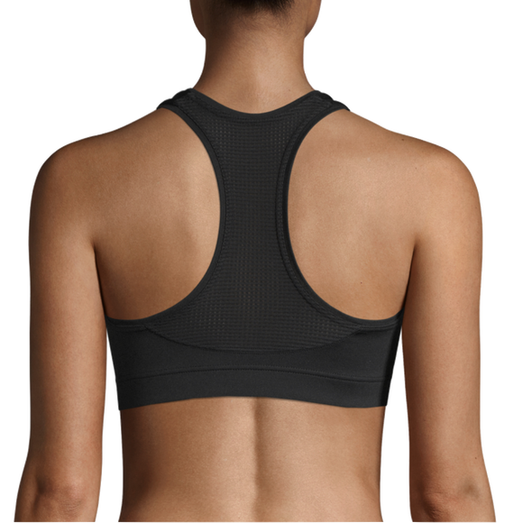 En kvinde ses bagfra iført Casall Iconic Sports Bra, Dame, Black. Billedet viser denne sports-bh's racerback-design og pasform på hendes øverste del af ryggen og skuldrene.