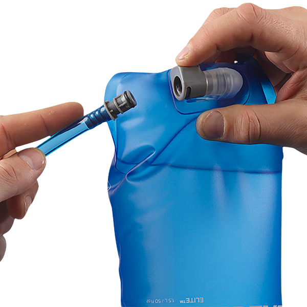 Et par hænder forbinder en blå Salomon Soft Reservoir 1,5L (Unisex, Clear Blue) slange med mundstykkets åbning. Dette fleksible reservoir, der er perfekt til vandreture, har tydelige målemarkeringer på forsiden.