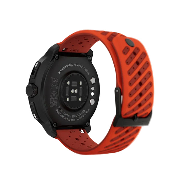 Et nærbillede af bagsiden af et sort Suunto Race 2 Coral Orange AMOLED GPS Sportsur viser urets sensorer, opladningskontakter og de indgraverede tekstdetaljer på urkassen. Uret er vinklet for at fremhæve det livlige, koralorange, perforerede armbånd og bagpanelet, hvilket understreger Suuntos avancerede multibånds-GPS-funktioner.